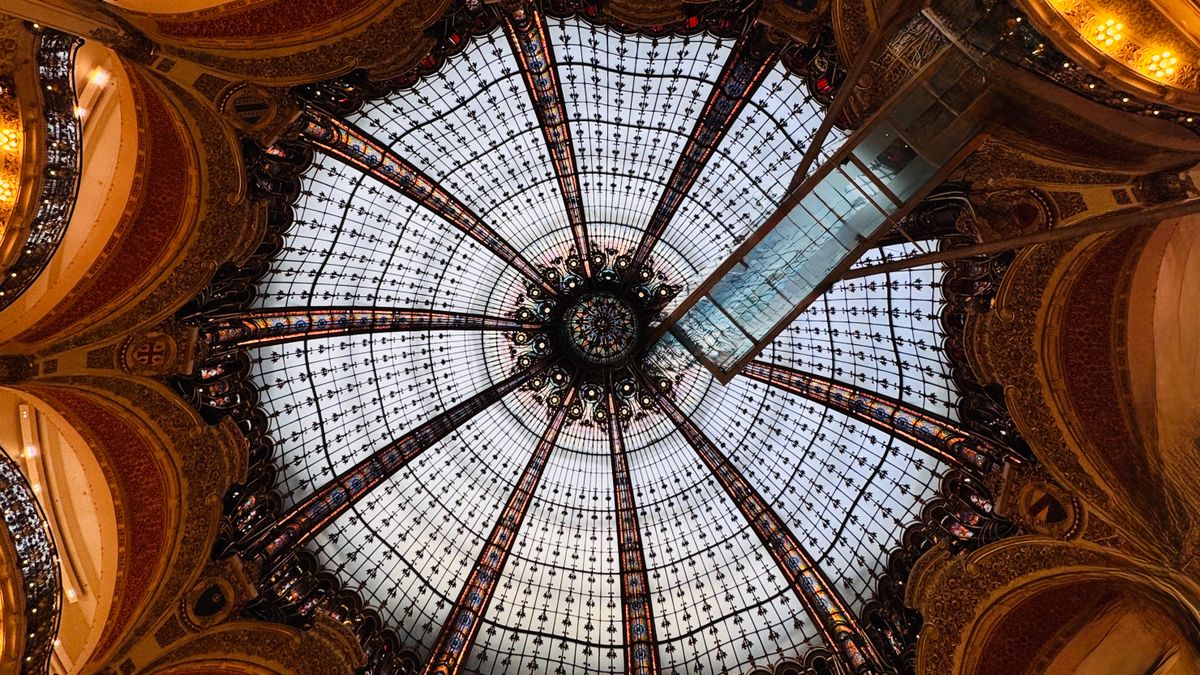 The Art Nouveau stained glass dome of Galeries Lafayette seen from below