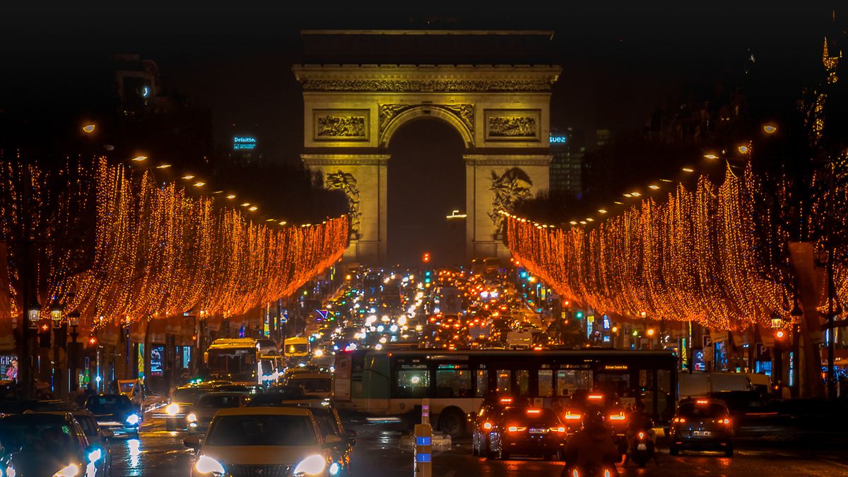 Champs-Élysées Christmas lights at night with the Arc de Triomphe in the background