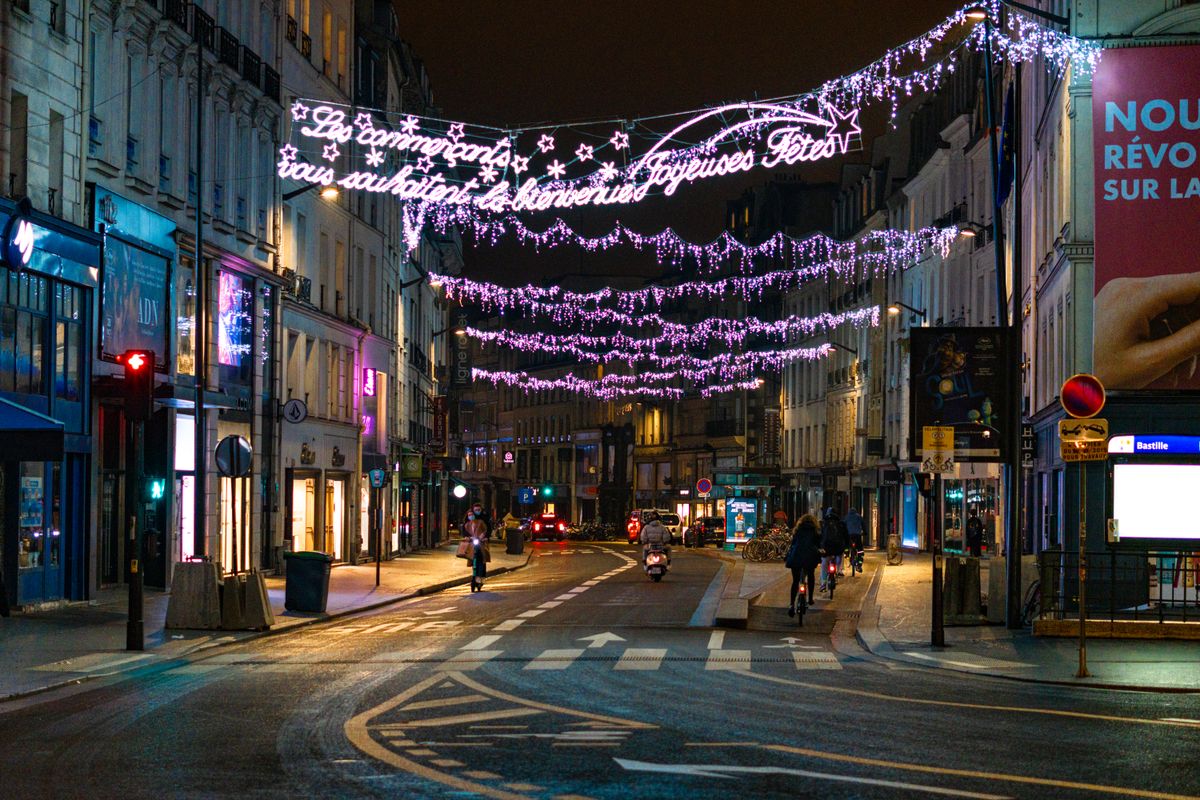 Christmas light garlands strung above a Paris street at night